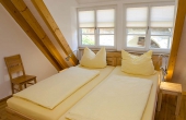 Schlafzimmer mit Doppelbett und Kleiderschrank, alles aus Massivholz - Ferienwohnung Idig, Weingut Thomas Steigelmann, Gimmeldingen (Pfalz), Neustadt / Weinstr.